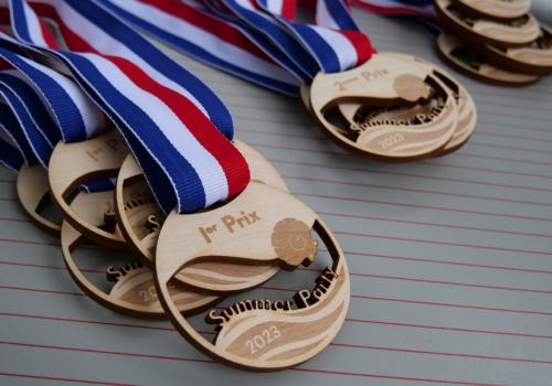 Laser engraving and cutting of wooden medals with personalized text and graphics