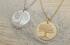 Gold and silver tree of life engraved medallion necklaces on textured background