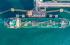 Top-down view of cargo ship being refueled and loaded